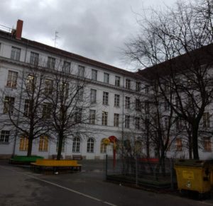 Graue Fassade mit vielen bunten Gesichtern: Die Rudolf Wissel Grundschule.