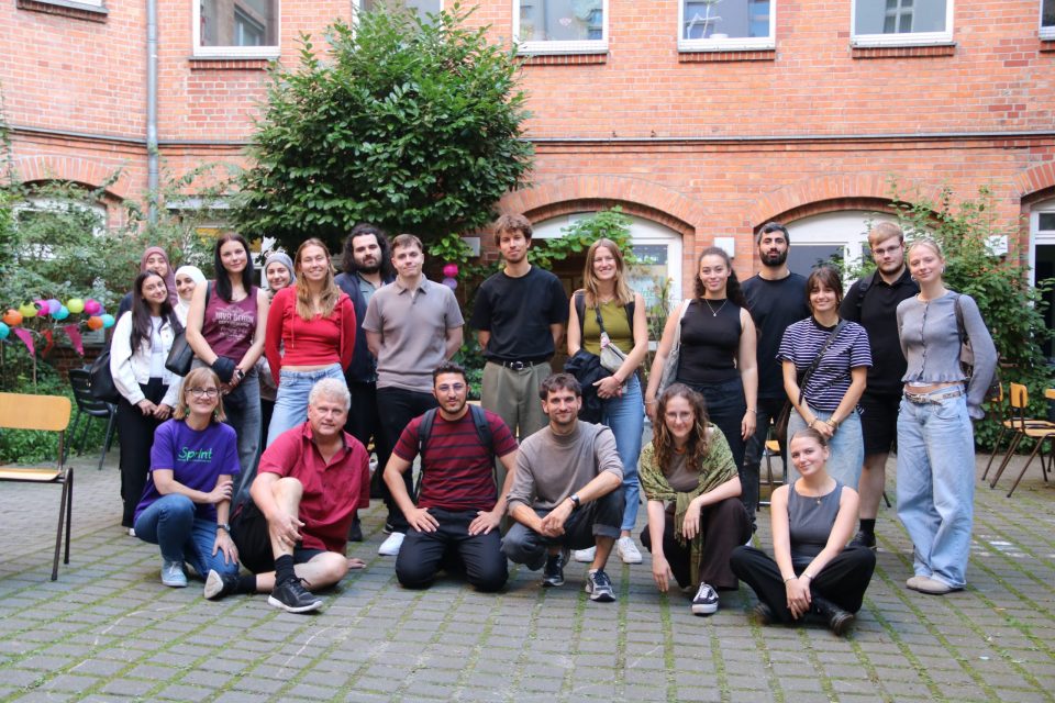 DaZ-Fortbildung 2025 Gruppenfoto Eine Gruppe ist vor einem Backsteingebäude versammelt.